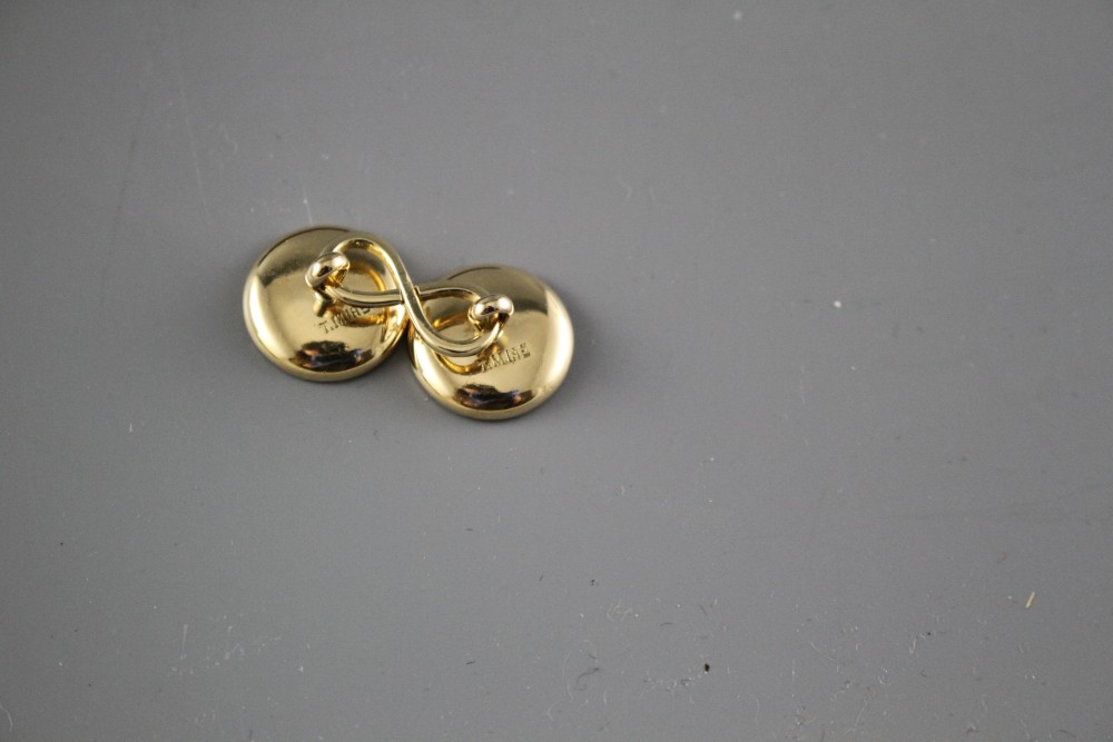 A pair of yellow metal (stamped TM 18ct), mother of pearl and enamel disc cufflinks, gross weight 10 grams, disc 14mm.